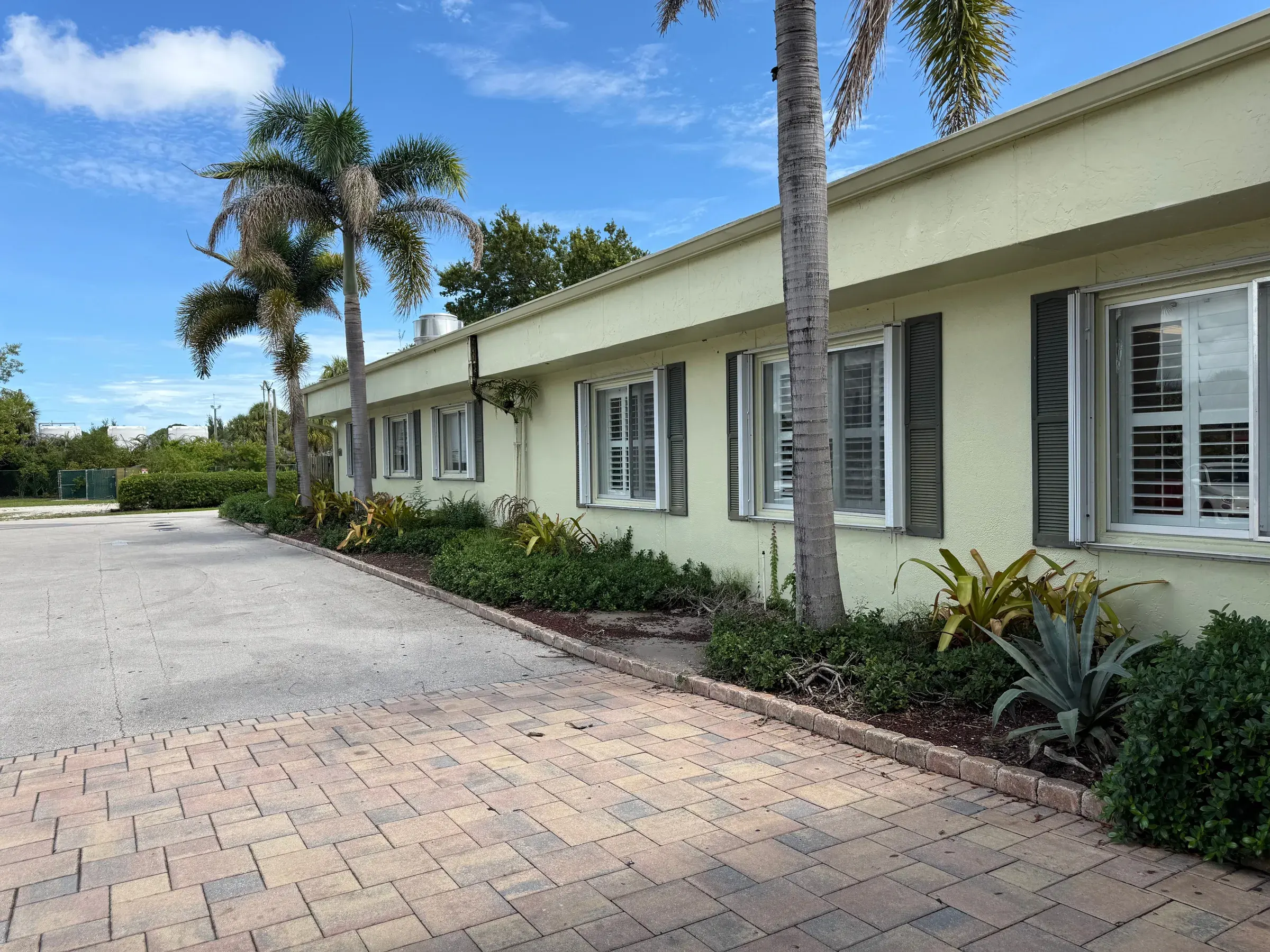 A residential wing of Vivo Healthcare Fort Pierce, palms along the brick walk